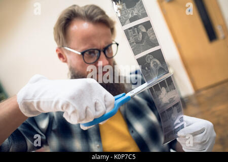 Photographer cutting film reel while working in studio Stock Photo