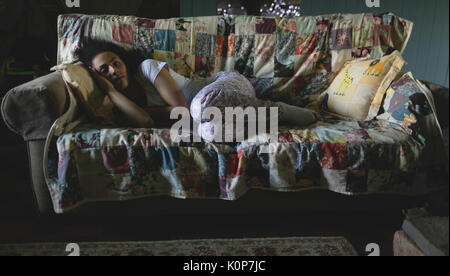 Woman lying on sofa at home Stock Photo