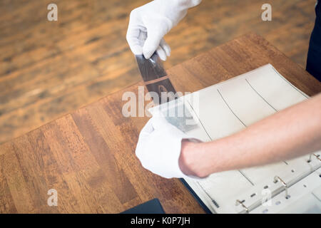 Cropped hand of photographer putting film in folder at table Stock Photo