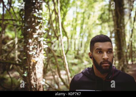 Close up of man looking away while standing in forest Stock Photo