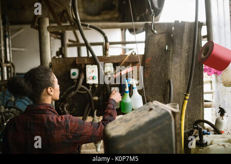 Attentive woman operating machine in barn Stock Photo