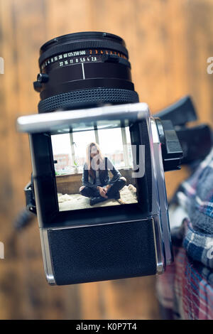 Cropped image of photographer by camera on tripod in studio Stock Photo