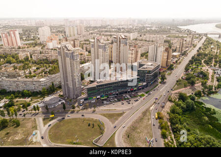 Residential district in a large metropolis with road junctions and houses. View of a newly built residential complex with a shopping center on the lower floors. Stock Photo