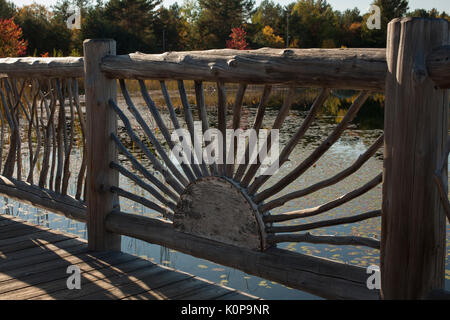 Caption 139/150    View of a rustic railing that is on the edge of a man-made pond at the Wild Center at Tupper Lake in the Adirondacks of Ne Stock Photo