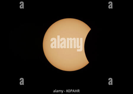 The Moon begins to cover the Sun's disk in the partial eclipse phase after first contact during the Great American Eclipse on August 21, 2017. Stock Photo