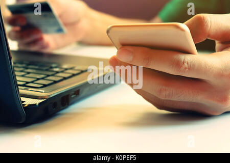 Man using smartphone with credit card pay by credit card and laptop for online shopping Stock Photo