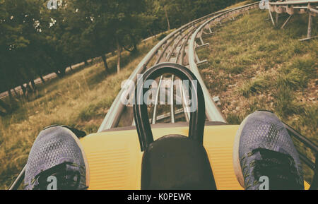 A persons feet and point of view during a ride on a roller coaster in a rural backyard. Stock Photo