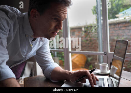 Close up of man in home office using computer Stock Photo