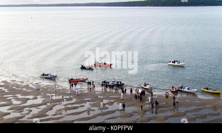 Boats parked next to the 'wicket' during the annual Bramble Bank cricket match between the Royal Southern Yacht Club and the Island Sailing Club of Cowes, which takes place on a sandbank in the middle of the Solent, which is only exposed at some of the lowest tides of the year. Stock Photo