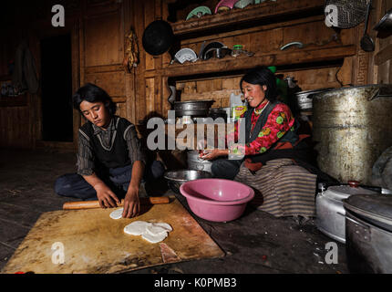 Tibetan mother and son cooking momos, the typical Tibetan dumpling, at home, Kham, Tibet Stock Photo