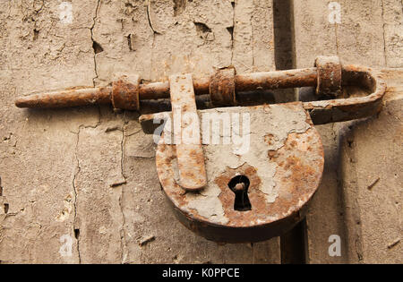 Old Rusted Bolt and Padlock on Wooden Door Stock Photo