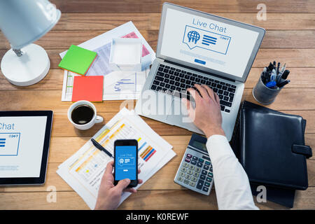 Icons and live chat text against cropped image of hand working at desk Stock Photo