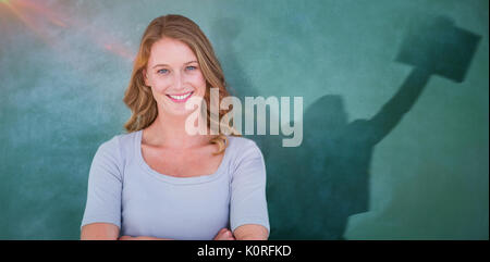Smiling teacher standing in front of blackboard against businessman jumping while holding briefcase Stock Photo