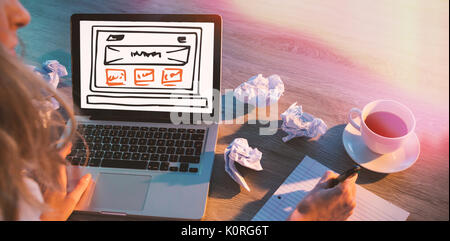 Illustration of computer monitor against cropped hands of female executive writing in diary Stock Photo