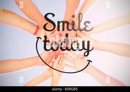 Digital composite image of smile today text against directly below shot of friends stacking hands Stock Photo