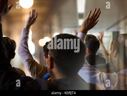 Digital composite of Business people with hands raised up at conference Stock Photo