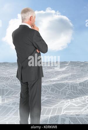 Digital composite of Businessman looking over sea of documents with cloud Stock Photo