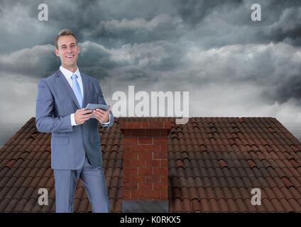 Digital composite of Businessman on roof with clouds Stock Photo