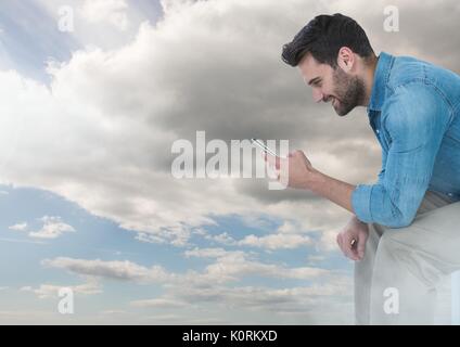 Digital composite of man on phone under sky clouds Stock Photo