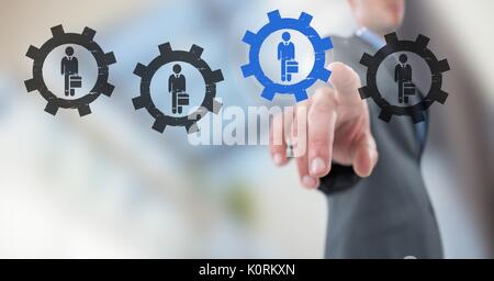 Digital composite of Businessman interacting and choosing a person from group of people icons with settings gear cogs Stock Photo