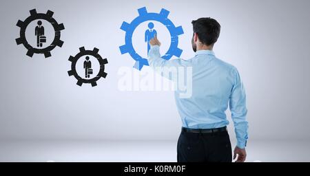 Digital composite of Businessman interacting and choosing a person from group of people icons with cog gear settings symb Stock Photo