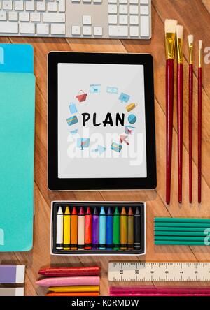 Digital composite of Table top with a tablet with web graphics on the screen Stock Photo