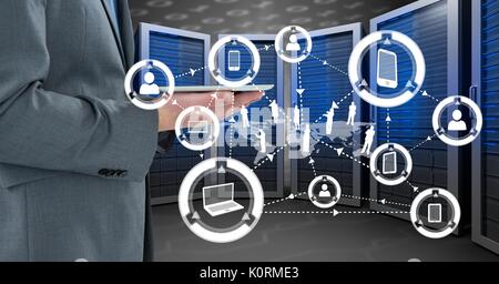Digital composite of Business man holding a tablet and graphics in server room Stock Photo