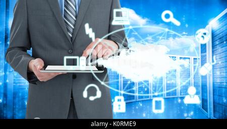 Digital composite of Business man holding a tablet and graphics in server room Stock Photo
