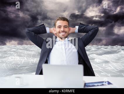 Digital composite of Businessman on laptop in sea of documents under dark sky clouds Stock Photo