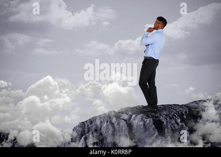 Thoughtful businessman standing against white background against yellow background Stock Photo