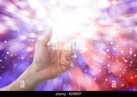 Hand of man pretending to touch an invisible screen against glowing background Stock Photo