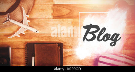 Blog text against white background against overhead view of diary with currency by digital tablet and luggage Stock Photo