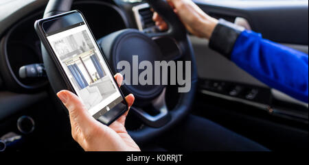 Sofa and curtain at home on mobile screen against man holding smartphone on his car Stock Photo