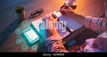 Graphic image of icons in circles against cropped hands of businessman writing in diary Stock Photo