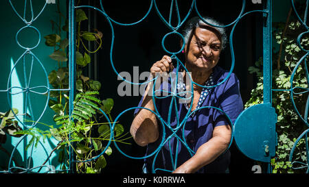 Old woman behind the bars Stock Photo