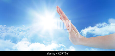 Hand of man pretending to touch invisible screen against view of overcast against blue sky Stock Photo