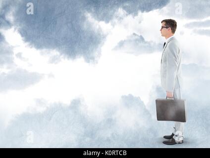 Digital composite of Businessman holding briefcase under sky clouds Stock Photo