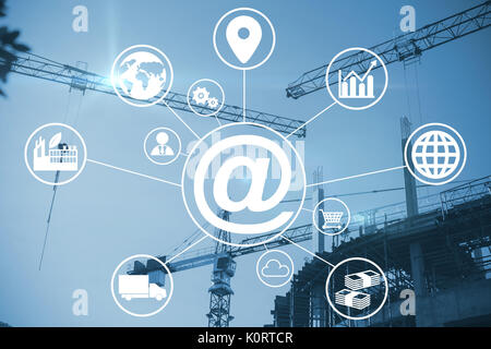 Composite image of at symbol amidst various icons against crane and building construction site Stock Photo
