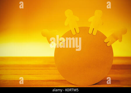 Close up of blue paper cut out figures on globe Stock Photo