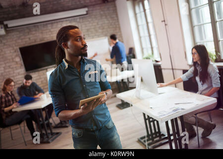 Portrait of young handsome male designer holding tablet Stock Photo