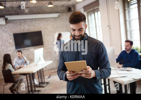 Portrait of young handsome male designer using tablet Stock Photo