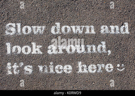 Slow down and look around its nice here stencil on a Canal towpath. Northamptonshire, UK Stock Photo