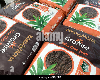 A stack of bags of Bord Na Mona Mini Chip Bark for dressing plant beds to retain moisture and discourage weeds in a garden centre Stock Photo