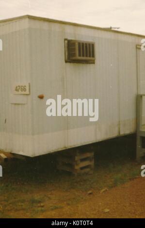 An exterior photograph of a plain, white trailer on a military base, an air conditioning unit can be seen, Long Binh, Vietnam, 1964. Stock Photo