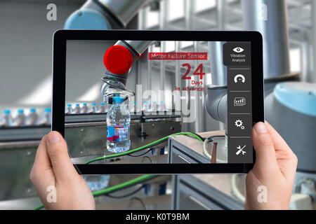 Engineer hand using tablet, automation robot arm machine in smart factory with tablet real time vibration analysis monitoring system application for c Stock Photo