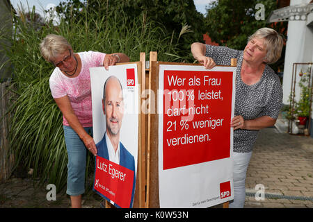 Ingeborg Dorschner (R), town chairwoman from Pleinfeld and her party colleague Micha Helles preparing SPD campaign posters for their distribution in Pleinfeld, Germany, 24 August 2017. The distribution of campaign materials is off to a sluggish start as fliers remain undistributed and information stands lack enough helpers - the Bundestag (Federal Legislature) electoral campaign in Bavaria is having a lukewarm start. Many party members are going on vacation instead of bringing out the vote. Photo: Daniel Karmann/dpa Stock Photo