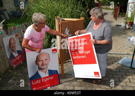 Ingeborg Dorschner (R), town chairwoman from Pleinfeld and her party colleague Micha Helles preparing SPD campaign posters for their distribution in Pleinfeld, Germany, 24 August 2017. The distribution of campaign materials is off to a sluggish start as fliers remain undistributed and information stands lack enough helpers - the Bundestag (Federal Legislature) electoral campaign in Bavaria is having a lukewarm start. Many party members are going on vacation instead of bringing out the vote. Photo: Daniel Karmann/dpa Stock Photo