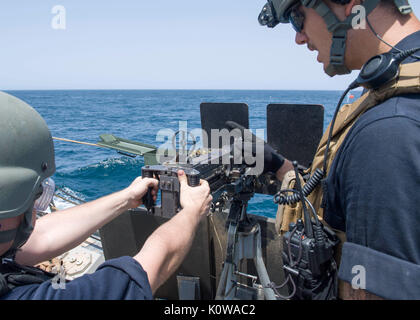 170816-N-YR245-299 5TH FLEET AREA OF OPERATIONS (Aug. 16, 2017) Gunner’s Mate 2nd Class James Maddox, from Lobelville, Tenn., gives firing instructions of the .50 caliber machine gun during a live-fire exercise aboard the Arleigh Burke-class guided-missile destroyer USS Pinckney (DDG 91). Pinckney is deployed in the U. S. 5th Fleet area of operations in support of maritime security operations designed to reassure allies and partners, and preserve the freedom of navigation and the free flow of commerce in the region.  (U.S. Navy photo by Mass Communication Specialist 2nd Class Craig Z. Rodarte/ Stock Photo