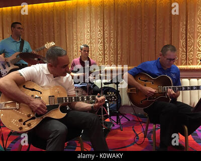 Members of the U.S. Air Force Band of the Golden West connect (and jam out) with Chief Master Sgt. Ramon 'CZ' Colon-Lopez, Command Senior Enlisted Leader for Headquarters United States Africa Command, at the Air Force Sergeants Association International Convention in Reno, Nevada, July 21, 2017.  This conference represented the professional and personal interests of nearly 11,000 active, retired, and veteran total enlisted member of the United States and their families--promoting enlisted concerns and creating opportunities for networking across the enlisted career fields. Stock Photo