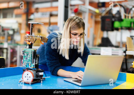 Young beautiful female engineer testing and programming Stock Photo